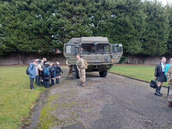 Pupils climbing into a military truck at the Barracks