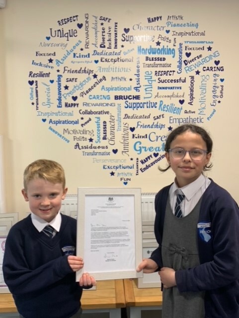 Bruche pupils Areen Sheli and Henry Melia smile with letter from Damian Hinds, School Minister